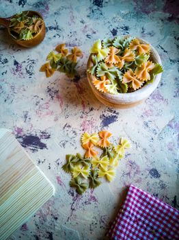 Colorful pasta ties in composition on light and rough background