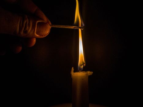 Matches burning to light a candle on black background