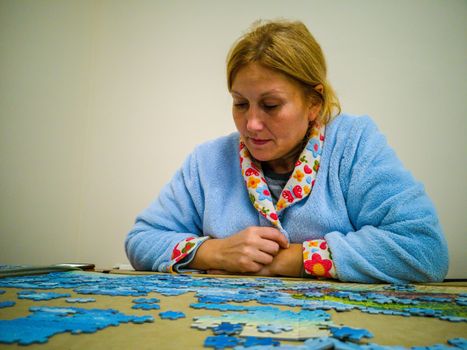 Woman in lab coat making puzzle at home