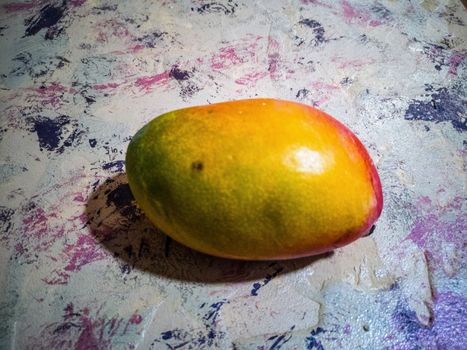 Ariel view of tropical mango on a rough background in purple tones