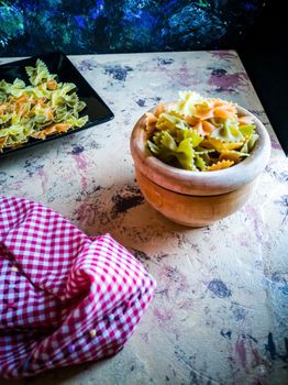 Colorful pasta ties in composition on light and rough background