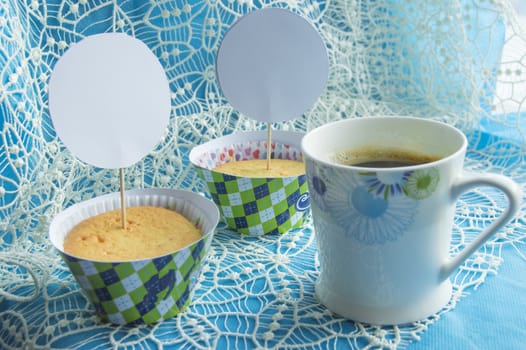 Coffee Cup, cupcakes on a lace napkin, card with copy space.