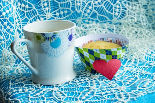 Cup of coffee, cupcake and hearts on the doily card with copy space.