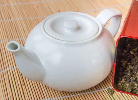 Teapot and a tin of traditional Asian green tea loose.