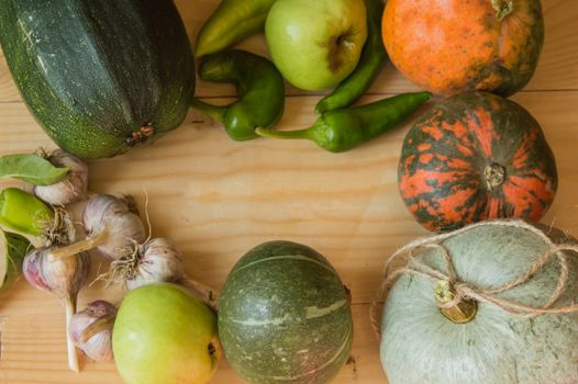 Harvest or Thanksgiving background with autumnal fruits and gourds on a rustic wooden table