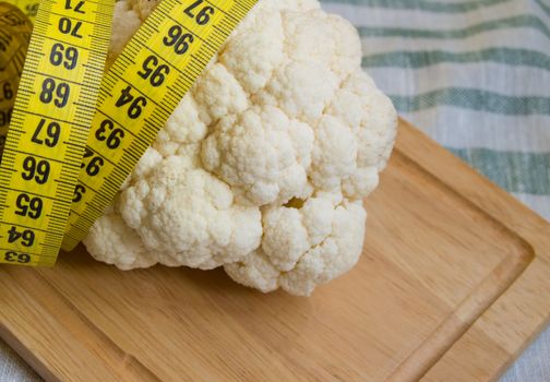 Cauliflower with a measuring tape. Healthy eating, vegetarian, diet. Weight loss