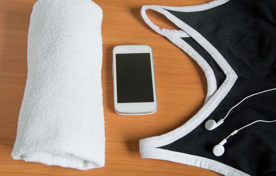 The concept of fitness and sport. Towel, mobile, T-shirt headphones