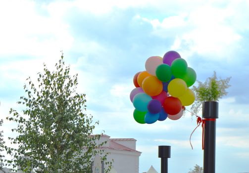 Colorful balloons on sky background in summer city Park.