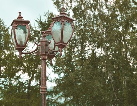 Vintage lantern on a background of trees and sky in the Park.