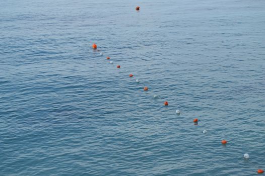 Separation buoys in the sea for safe swimming on the beach.