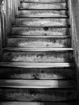 Old worn, wooden staircase in monochrome.