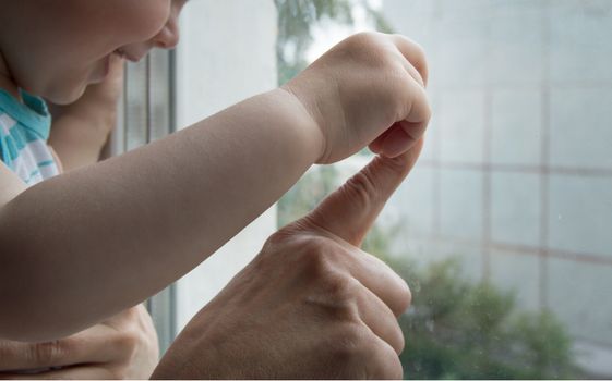 concept of a happy family - an adult holds the hand of a baby.