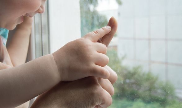 concept of a happy family - an adult holds the hand of a baby.