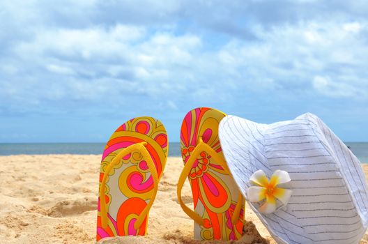 Beautiful background beach, flip flops, hat, sand. The concept of vacation and relaxation
