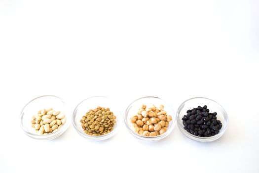 four bowls with white beans, lentils, peas and black beans