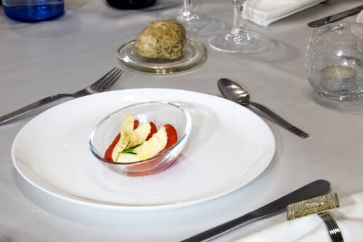 Four slices of tomato with mozzarella and rosemary oil served in small cup