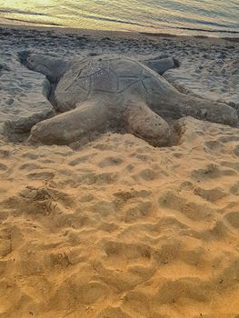 Sand turtle built on the beach much like a sandcastle