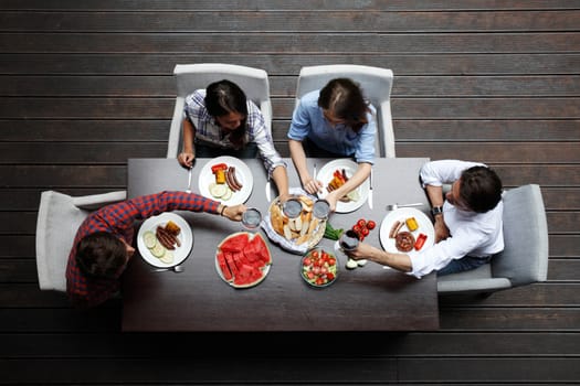 Four friends having dinner, top view