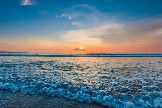 Amazing colorful sunset over sea form Bali beach