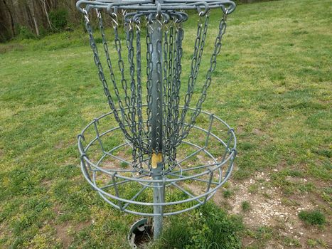 flying disc golf metal chain cage or basket and green grass or lawn