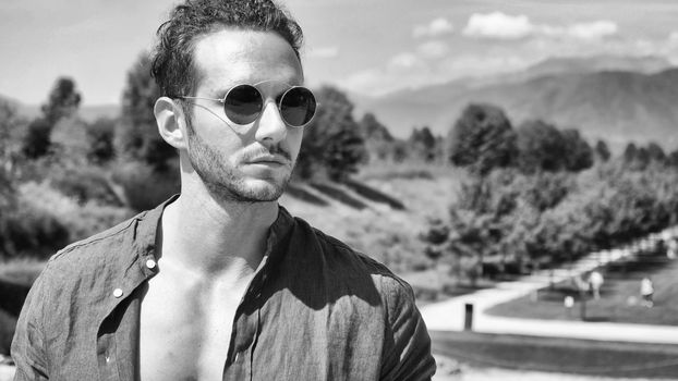 Handsome muscular man posing in European luxury garden in Turin, Italy