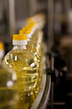 Sunflower oil in the bottle moving on production line. Shallow dof