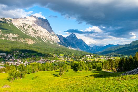 Panorama of Cortina d'Ampezzo with green meadows and alpine peaks on the background. Dolomites, Italy