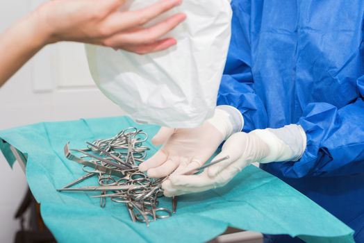 Scrub nurse preparing medical instruments for operation