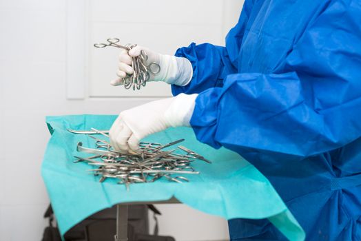 Scrub nurse preparing medical instruments for operation