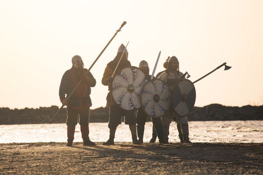 Slavic warriors reenactors with wearpons and shields training fighting outdoors at seaside