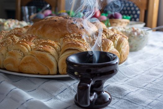 Smoke rising from Cresset on the table with food on ortodox easter