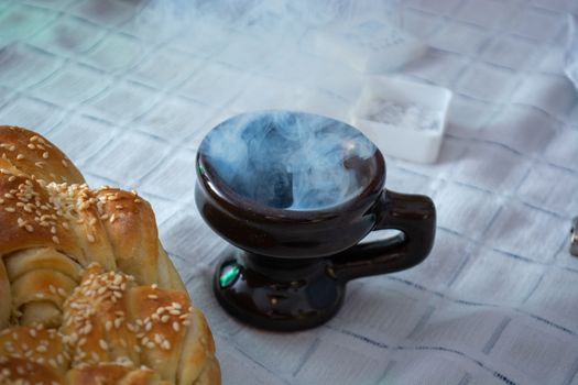 Smoke rising from Cresset on the table with food on ortodox easter