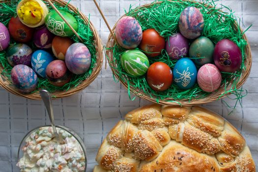 Table ful of food on easter holyday. Colored eggs and bread shoot from upper angle