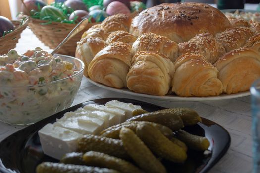 Table ful of food on easter holyday. Colored eggs and bread