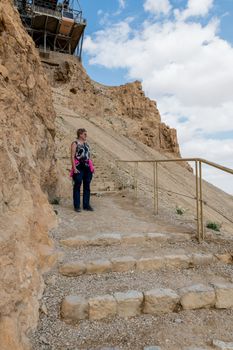 woman walking down the 800 steps of the masada mountain in israel
