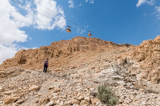 woman walking down the 800 steps of the masada mountain in israel