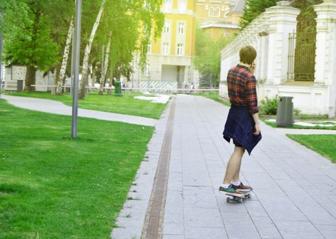 Hipster man skateboarding in the Park, the concept of outdoor activities and sports. Selective focus, sunlight.