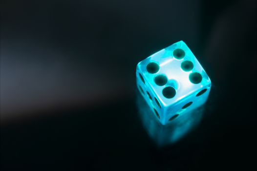 Transparent Glowing Teal Dice on Reflective Surface