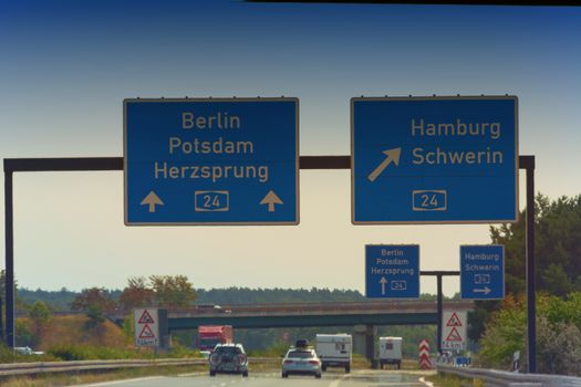 German motorway sign with inscription in German direction arrow to the cities - Berlin, Potsdam, Herzsprung, Hamburg and Schwerin