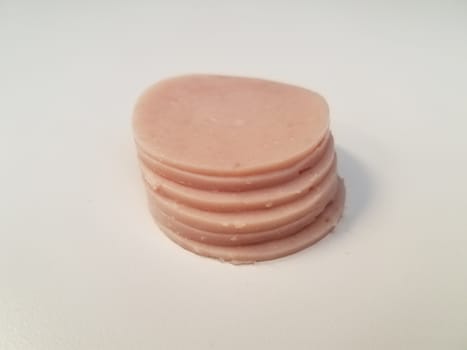 stack of circular pink ham meat on white surface or table