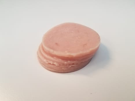 stack of circular pink ham meat on white surface or table