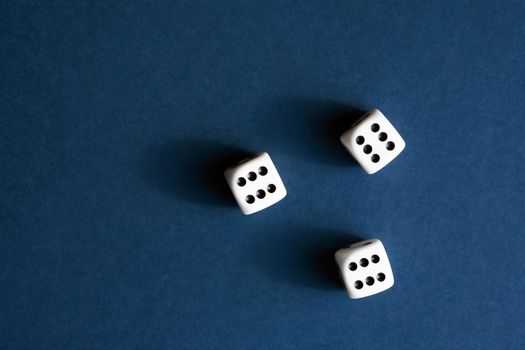 Three dice cubes on blue background with free space