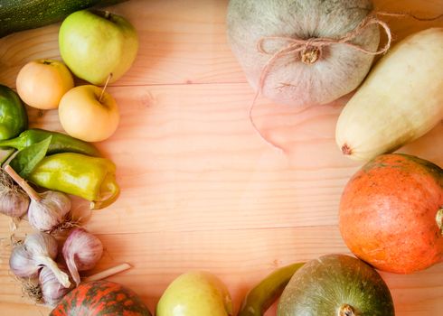 Harvest or Thanksgiving background with autumn fruits and gourds on a rustic wooden table.
