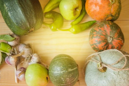 Harvest or Thanksgiving background with autumnal fruits and gourds on a rustic wooden table