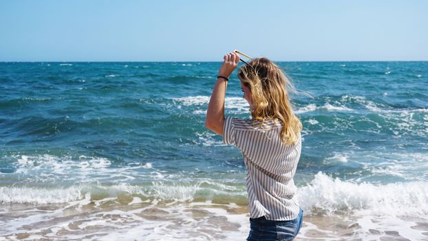 Beautiful bohemian styled and tanned girl at the sea beach in sunlight