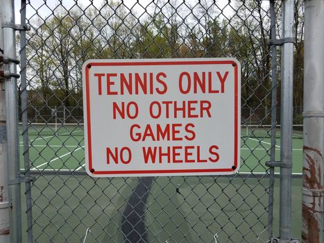 tennis only no other games no wheels red and white sign on metal fence at tennis court