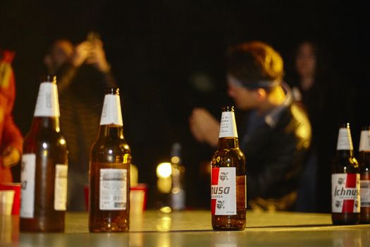 Series of empty beer bottles and resting on the wall at a party of young boys