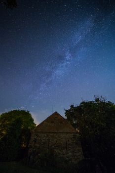 Milky way over old brick and stone building at night