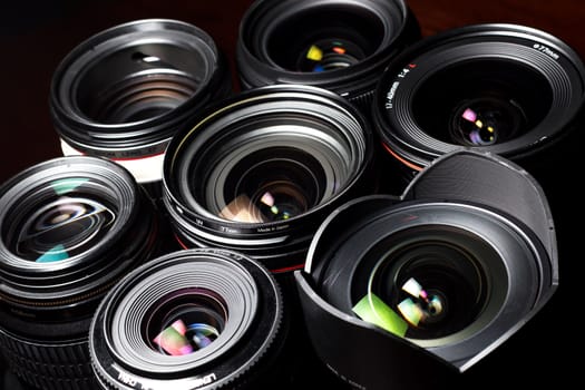 Set of various DSLR lenses with colorful reflections - shot from above