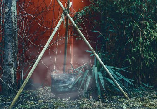 smoking cauldron in the dark, camping site equipment, Halloween and witchcraft